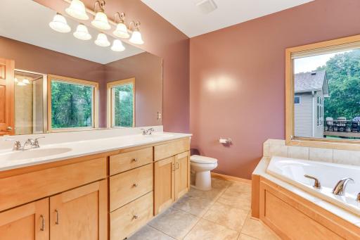 The private full primary bathroom features double sinks, a tiled floor, and a separate tub and shower for added luxury and functionality.