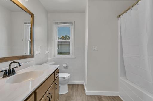 This main level bathroom has been fully updated. Custom cabinetry offers ample storage and a high-end look, while modern finishes and fixtures create a fresh, polished feel