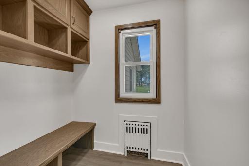 Bright and welcoming brand-new foyer features custom cabinetry and a built-in bench, offering both style and functionality.