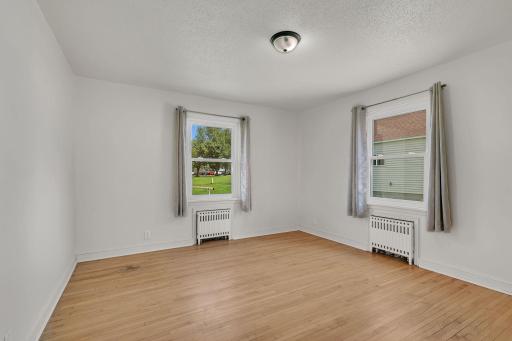 3rd main floor bedroom with large closet, refinished original hardwood floors, & large windows allowing for ample sunlight.