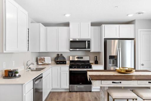 Stainless steel appliances and quartz countertops. Photo is of model home. Colors and options may vary. Ask Sales Agent for details.