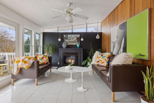 Sunroom with access to the deck leading down to the pool. Includes gas fireplace and heated Terrazzo floors