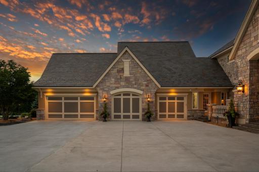 A spacious, beautifully designed 4-car garage featuring stone accents, arched detailing, and elegant carriage-style doorsâoffering both functionality and curb appeal.