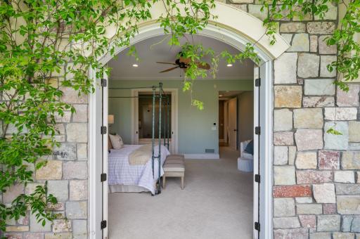 A unique stone archway welcomes you into the luxurious primary suite from the private balcony.