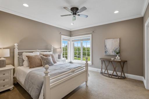 Spacious bedroom on the upper level with plenty of natural light offers a complete suite with a private bathroom and walk-in closet, providing comfort and functionality.