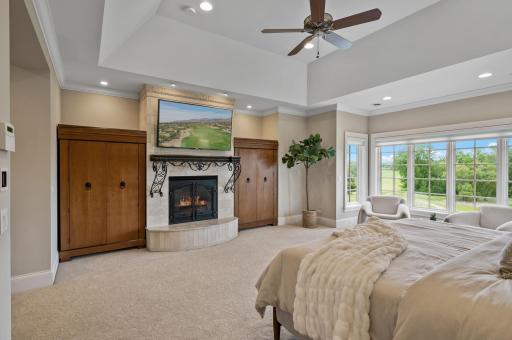 Thoughtfully designed, the second primary suite features a cozy fireplace, practical built-in storage, and a bright sitting area with scenic views.