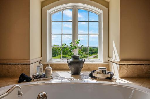 Elegant details surround the soaking tub, creating a perfect spot to unwind and enjoy the view.