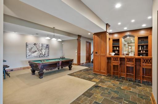 The impressive custom bar is ready for your next gathering, conveniently located near the pool table in the lower level.