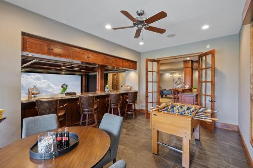 The well-appointed bar area on the lower level offers a convenient spot to serve guests while enjoying the theater room and other amenities on the lower level.