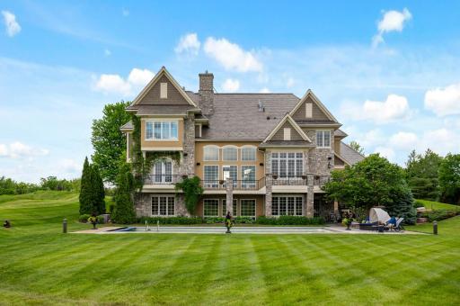 An impressive view of the rear of this Eden Prairie estate, showcasing the expansive grounds and inviting pool area perfect for outdoor living.