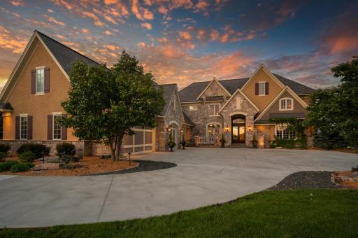 Imagine coming home to this inviting residence, its beauty enhanced by the warm glow of evening.