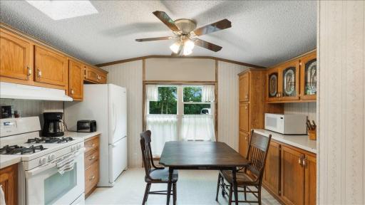 The kitchen and dining area overlook the wooded backyard.