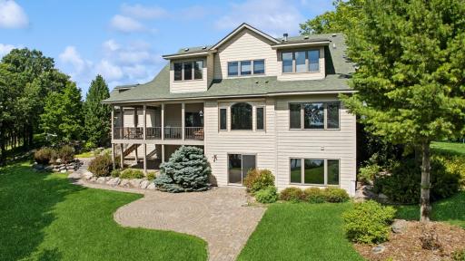 The lake side of the house showcases the thoughtful design and use of windows/natural light in the house. The professional landscaping enhances the natural beauty of the treed lot. The covered deck and paver patios are awesome outdoor living spaces!