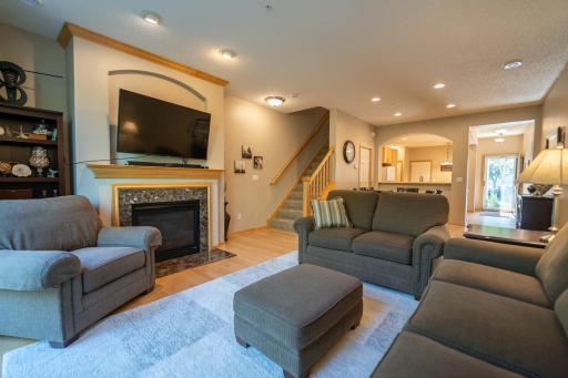 Living room features beautiful hardwood floors, open floor plan, gas burning fireplace, can lighting and sliding glass door to private patio in backyard.