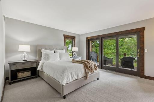 Main level primary bedroom with private deck, the perfect place to watch the sunrise.