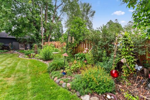 The backyard features established gardens full of returning plants (perennials).