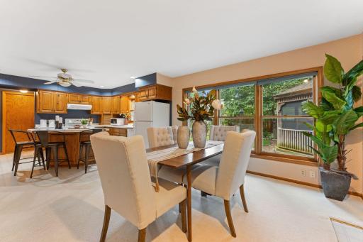 The kitchen is open to a dining space, large windows and a sliding door out to a patio.