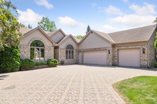 Paver driveway, three-car heated garage and front of home.