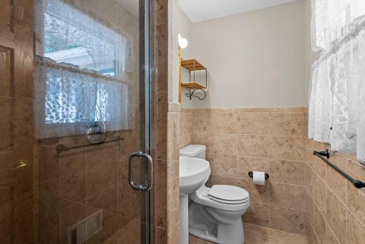 Updated in 2015, the private en suite bath is a lovely retreat with a walk-in tiled shower, classic wainscoting, and tile flooring.