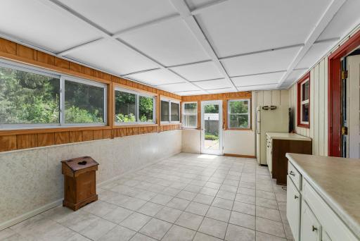 Step into the sunny, spacious 3-season sunroom—complete with built-in cabinetry, additional counter space, tile floors, and even a second fridge. Perfect for sipping morning coffee, indulging a favorite hobby, or hosting friends!