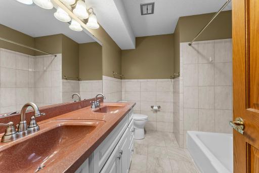 Fully remodeled bathroom around 2016. With a double vanity, stylish countertops, tiled shower/tub combo, and charming tile wainscoting, it’s perfect for family or guests. A nearby linen closet adds even more functionality.