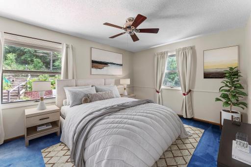 Down the hall, the serene primary bedroom features plush carpeting, a ceiling fan, and a thoughtfully designed closet with custom built-ins for easy organization.