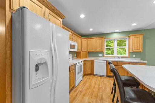 Kitchen features white appliances and a convenient electric stove.