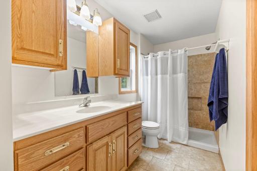 Private Â¾ primary bath featuring tile flooring and a tiled shower.