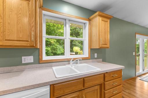 Kitchen window frames serene views of the backyard and the Groundhouse River.