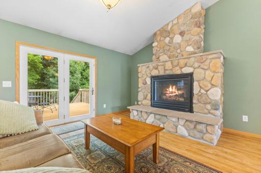 Stone gas fireplace anchors the living room, which opens seamlessly to the back deck.