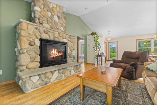 Cozy living room with a beautiful stone gas-burning fireplace as the centerpiece.