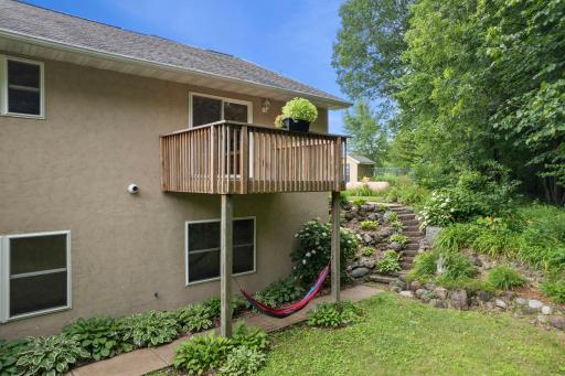 View of the primary bedroomâs deck from the landscaped backyardâelevated and serene.