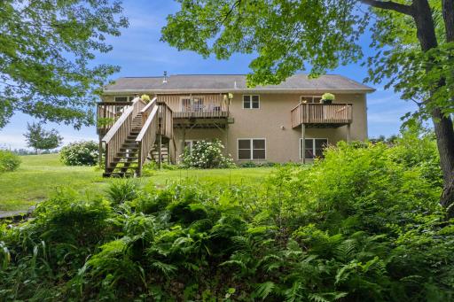 View of the back of the home from the backyard, showcasing decks and outdoor living spaces.