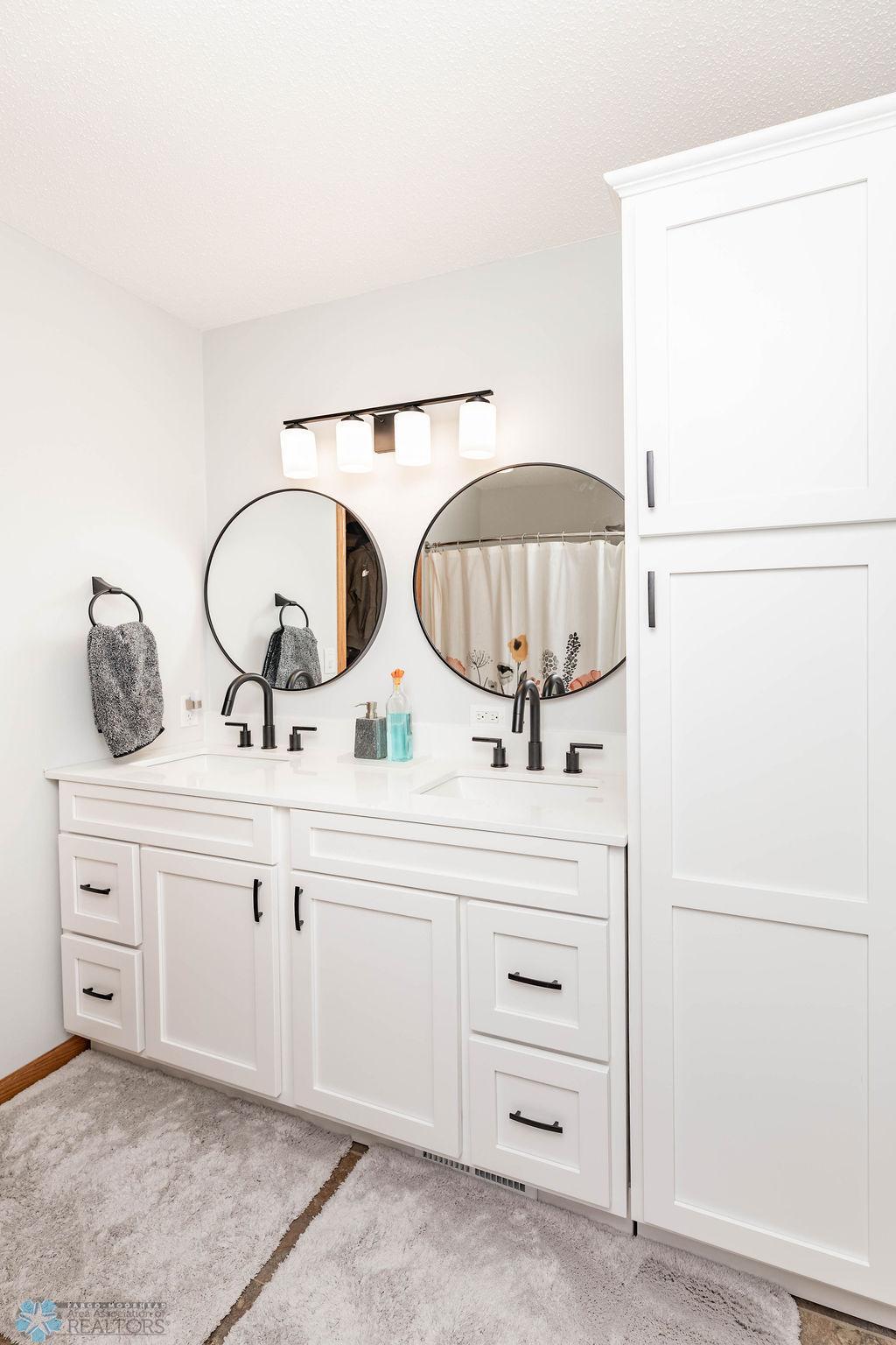Primary Bath features double sinks, linen tower, 3/4 bath