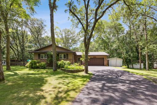 Nestled on a heavily wooded lot, complete with additional sheds and garden areas