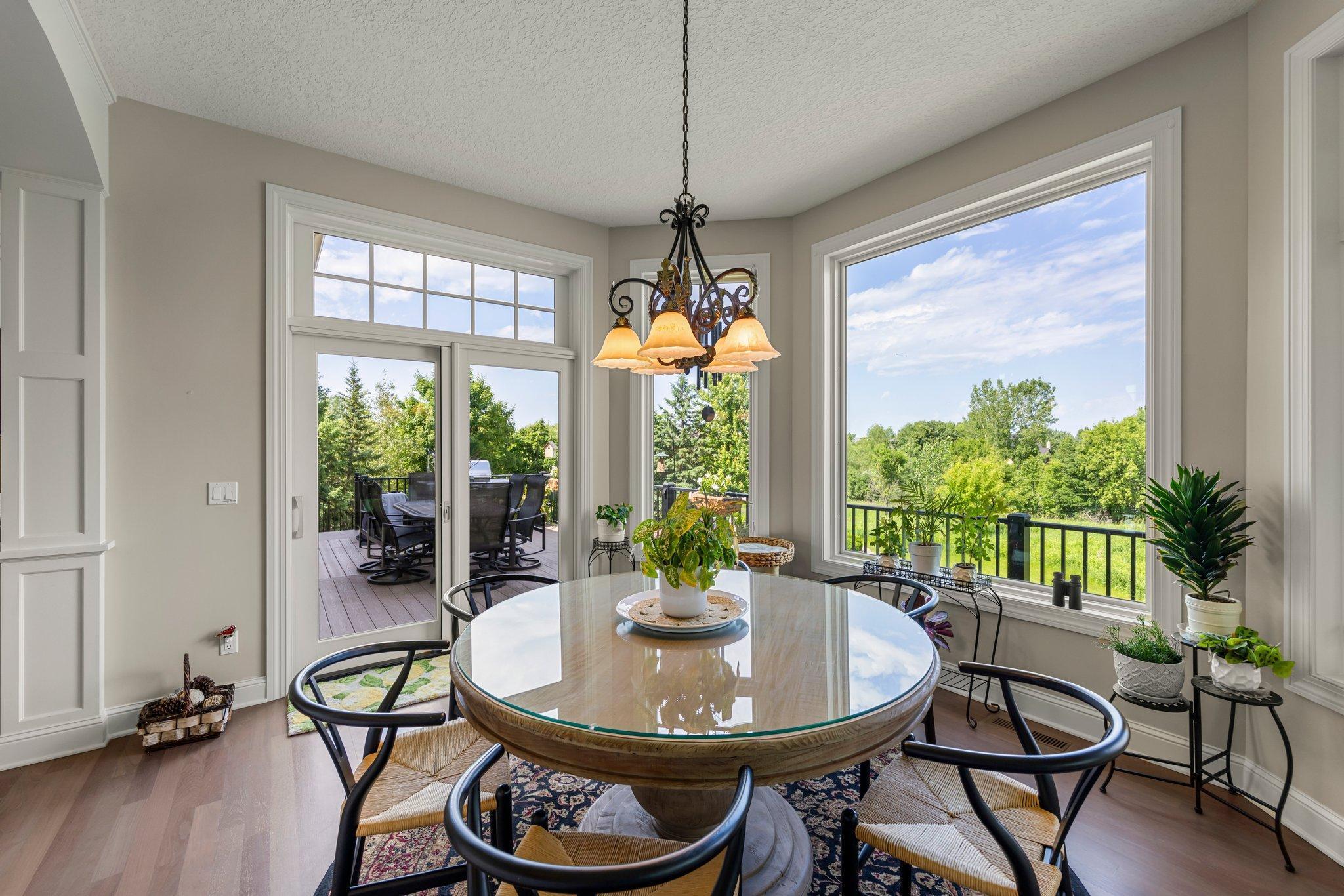 Sunny dining area with oversized windows and access to the deck and screened porch. Enjoy peaceful views of the backyard and surrounding landscape—perfect for everyday meals or morning coffee.