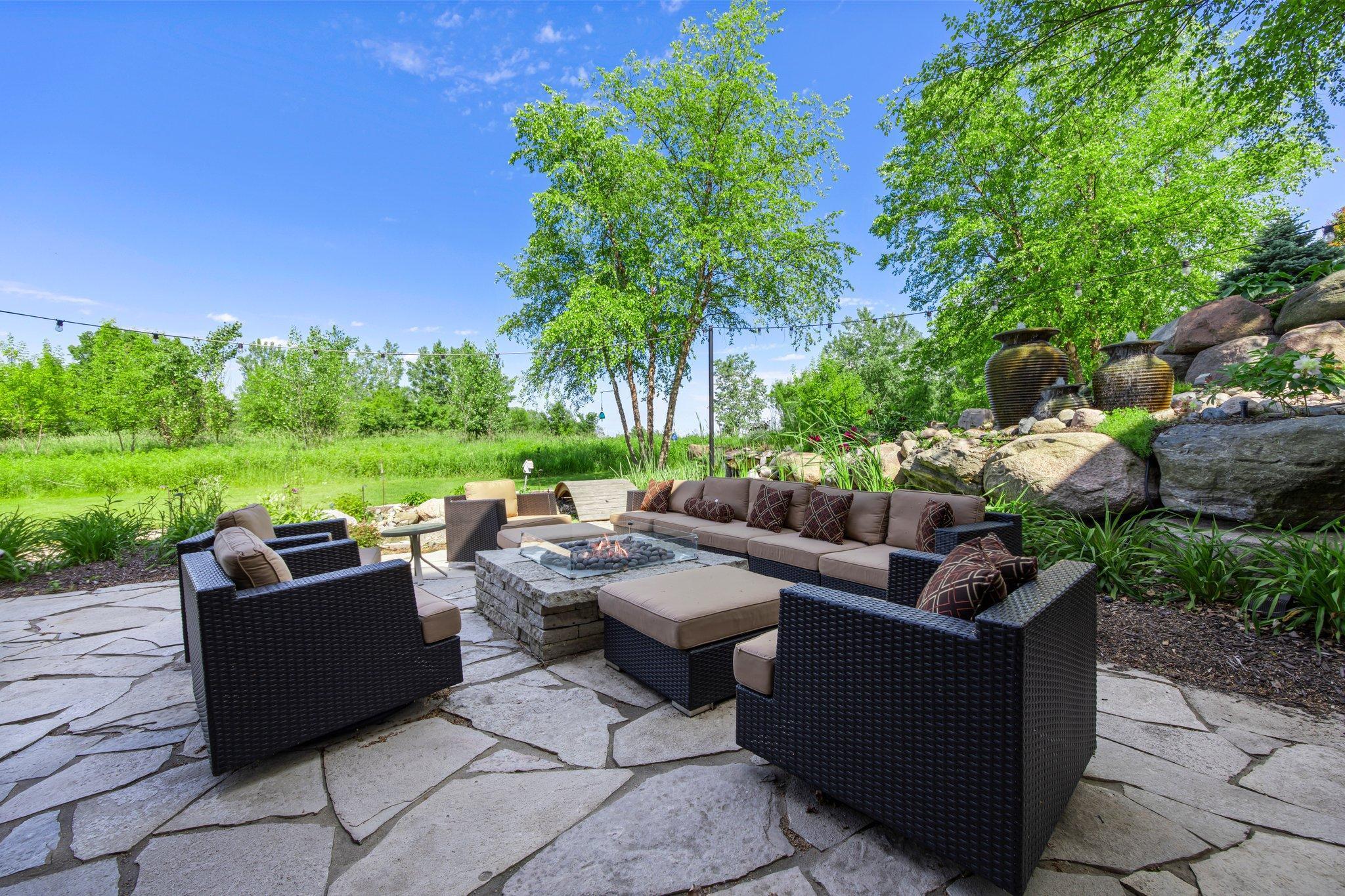 Tucked into a private natural setting, this stone patio features a gas fire pit which is ideal for gathering with friends or unwinding at sunset.