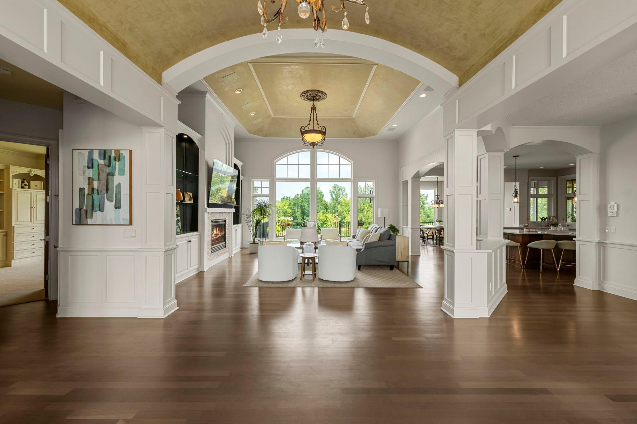 Open-concept living with soaring ceilings, arched openings and detailed millwork. Sun-filled great room features a fireplace, built-ins, and expansive windows with panoramic views.