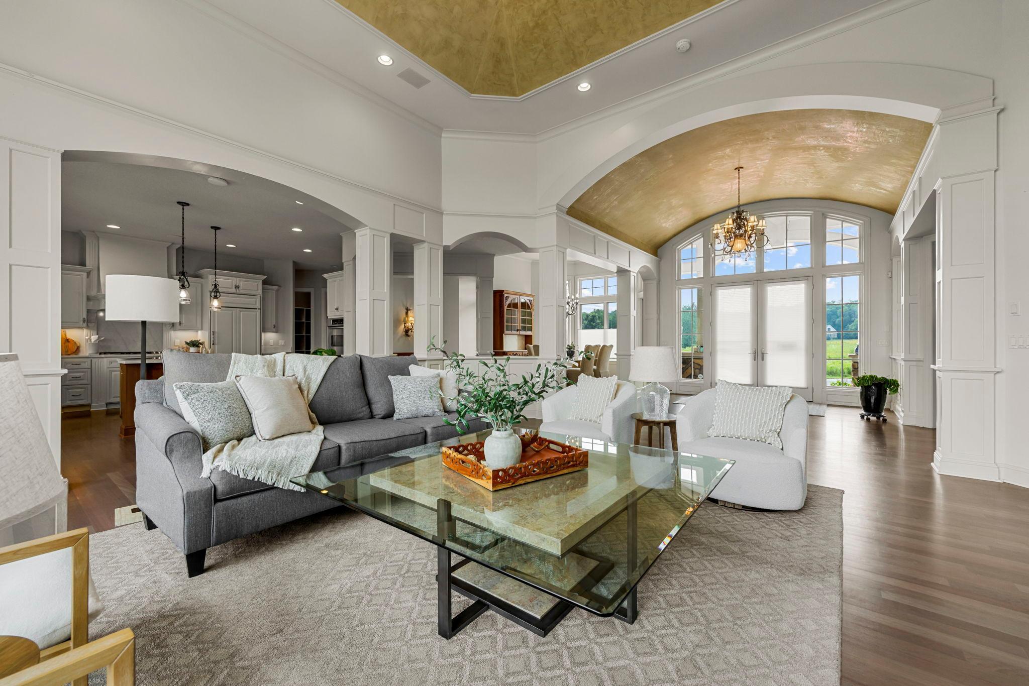 Expansive open-concept layout with elegant ceiling detail, arched transitions, and rich millwork. Seamless connection from great room to chef’s kitchen and front foyer, with stunning natural light and sweeping views throughout.