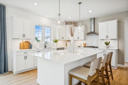(Photo of a decorated model, actual homes finishes will vary) Enjoy plenty of seating at the kitchen island and dining area adjacent to the kitchen. Perfect for entertaining or enjoying a meal together.