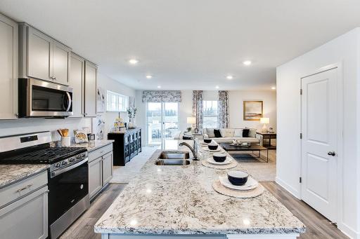 The spacious kitchen flows between the family room and eating area for convenience. Model picture shown. Colors and finishes may vary.