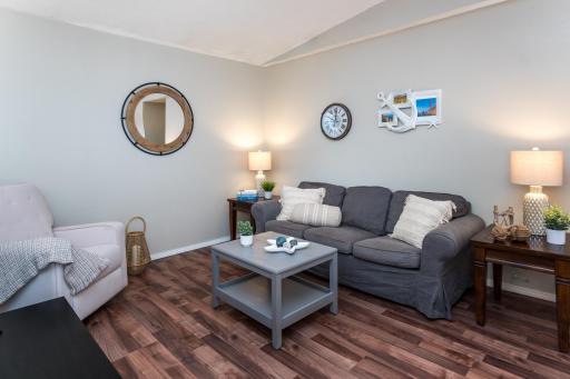 Vaulted living room with wood-style flooring