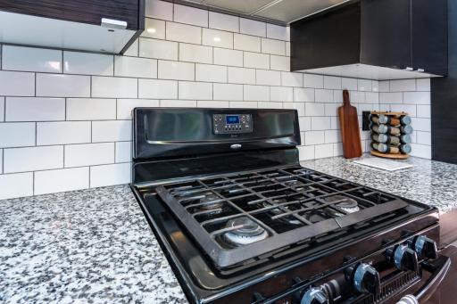 Granite surfaces, subway backsplash, gas range