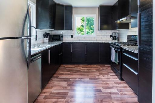 Sleek Kitchen Style with Subway Backsplash, Stainless Appliances, Gooseneck Faucet & Double Windows