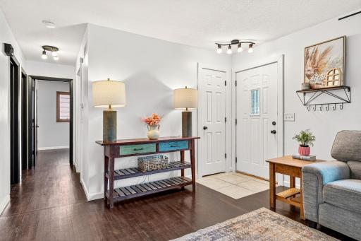 Welcoming entryway with updated lighting and tile flooring for easy maintenance. The open layout flows seamlessly into the spacious living area, providing a functional and inviting design.