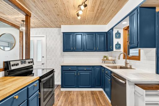 Stainless steel appliances, modern fixtures, and ample counter space and butcher block counter for meal prep.