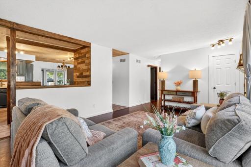 Charming living room view showcasing the wood-accented pass-through to the kitchen and open concept feel.