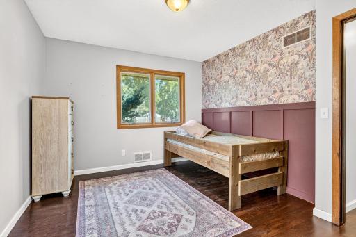 Spacious secondary bedroom featuring a decorative accent wall and double windows.