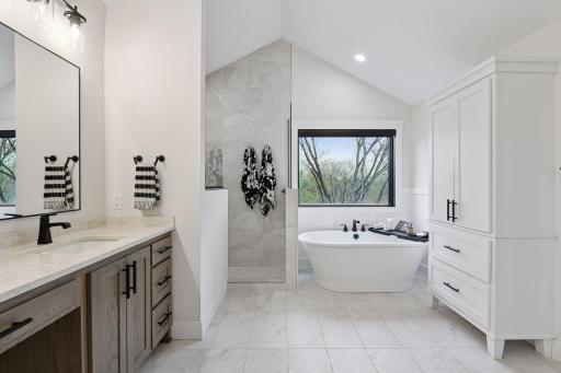 Spa-like primary suite including walk-in shower, free standing tub and large dual sink vanity