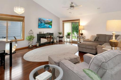 Spacious living room with vaulted ceilings, electric fireplace, and patio door leading to the backyard..jpg